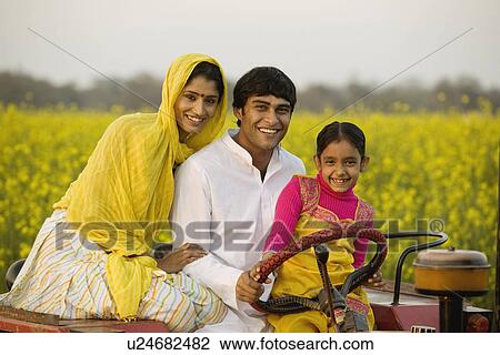 Stock Image - A typical rural family on a tractor. Fotosearch