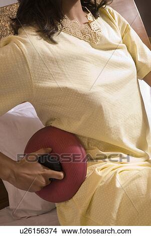 A woman applying a hot water bag View Large Photo Image Picture - A woman applying a hot water bag. Fotosearch