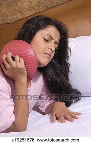 A woman applying a hot water bag View Large Photo Image Stock Photograph - A woman applying a hot water bag. Fotosearch
