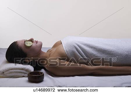 Stock Image - A woman lying down in a spa. Fotosearch