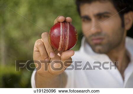 Bowler checks the cricket ball View Large Photo Image Stock Photograph - Bowler checks the cricket ball. Fotosearch