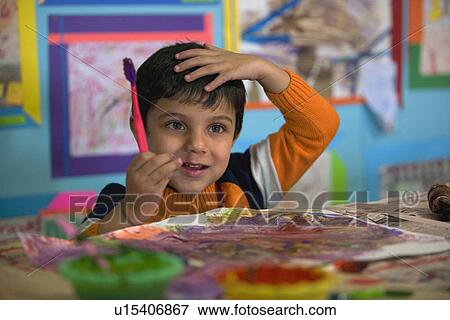 Stock Photo - Boy holding a paint brush. Fotosearch