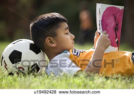 Stock Photo - Boy lying with soccer ball under his head. Fotosearch