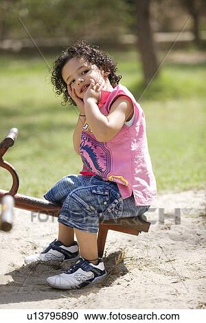 Boy sitting on a see-saw View Large Photo Image Stock Image - Boy sitting on a see-saw. Fotosearch