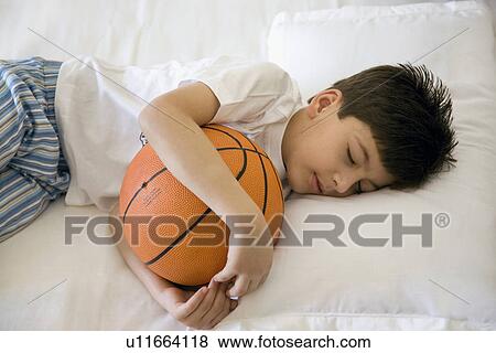 Boy sleeping with a basket ball View Large Photo Image Stock Photo - Boy sleeping with a basket ball. Fotosearch