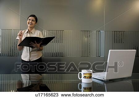 Stock Image - Business executive holding a file. Fotosearch