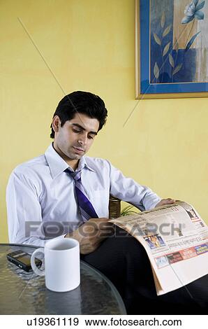 Stock Photo - Business executive reading the papers. Fotosearch