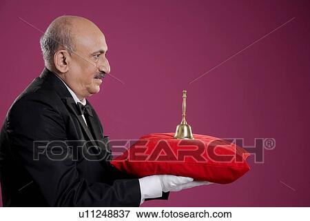 Butler carrying a bell View Large Photo Image Stock Photo - Butler carrying a bell. Fotosearch