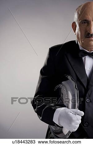 Stock Image - Butler carrying a tray. Fotosearch