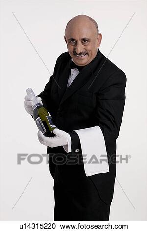 Stock Image - Butler holding a bottle. Fotosearch