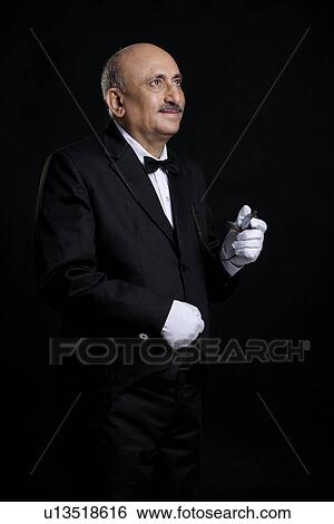Stock Photograph - Butler holding a pocket watch. Fotosearch