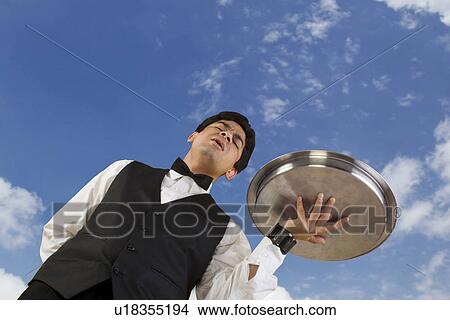 Butler holding a tray View Large Photo Image Picture - Butler holding a tray. Fotosearch