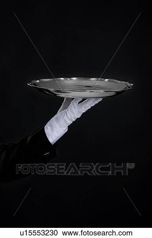 Stock Image - Butler holding a tray. Fotosearch