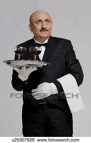 Stock Photograph - Butler holding some drinks. Fotosearch