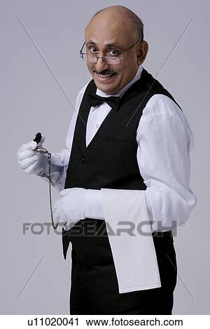 Stock Image - Butler with a pocket watch. Fotosearch