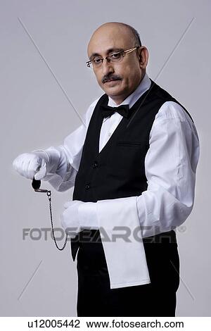 Stock Image - Butler with a pocket watch. Fotosearch