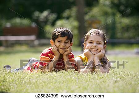 Stock Photo - Children lying in a park. Fotosearch