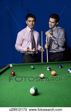 Stock Image - Colleagues playing pool. Fotosearch