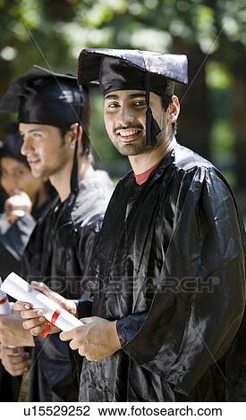 Stock Image - College students at graduation ceremony. Fotosearch