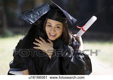 Stock Image - College students at graduation ceremony. Fotosearch