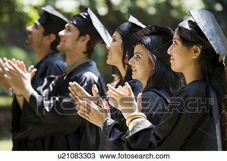 Stock Image - College students at graduation ceremony. Fotosearch