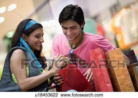 Stock Image - Couple checking their purchase. Fotosearch