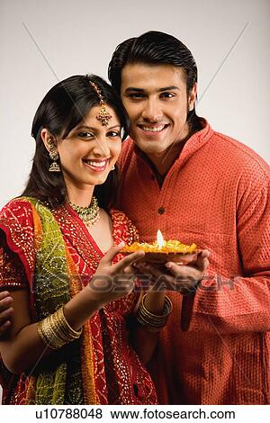 Couple holding a diya View Large Photo Image Stock Photo - Couple holding a diya. Fotosearch