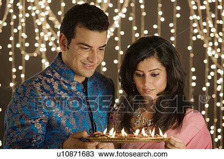 Stock Image - Couple with a tray of diyas. Fotosearch