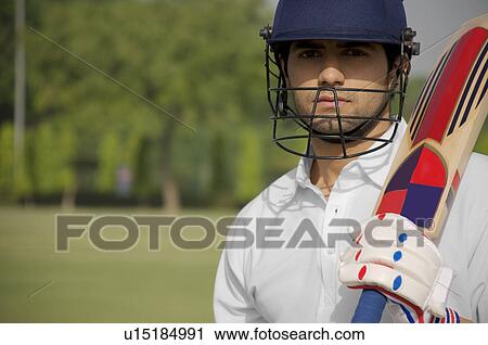 Stock Image - Cricketer holding a bat. Fotosearch