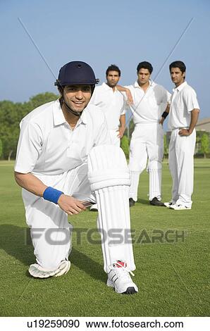 Stock Image - Cricketer wearing his cricket pads. Fotosearch