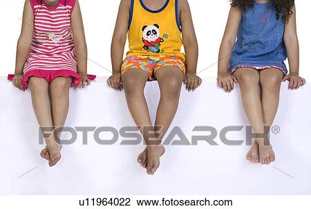 Crossed legs of children on a bench View Large Photo Image Stock Image - Crossed legs of children on a bench. Fotosearch
