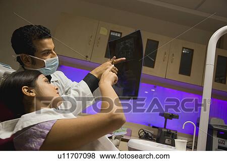 Stock Photo - Doctor and patient looking at X-ray. Fotosearch