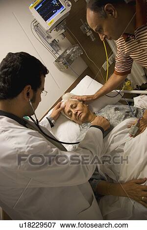 Stock Photo - Doctor checking patient's heartbeat. Fotosearch