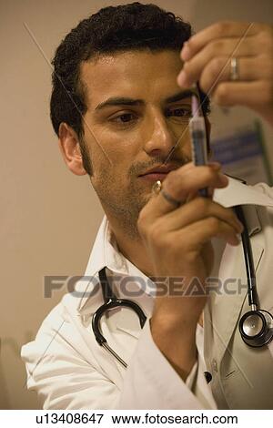 Doctor filling up a syringe View Large Photo Image Stock Photo - Doctor filling up a syringe. Fotosearch