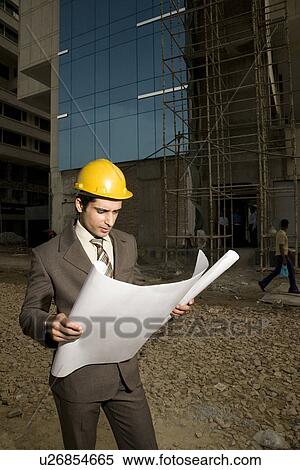 Stock Photography - Engineer looking at blueprints. Fotosearch