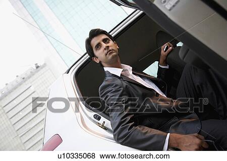 Executive coming out of a car View Large Photo Image Stock Photo - Executive coming out of a car. Fotosearch