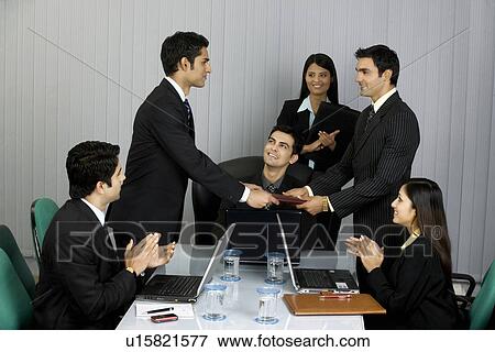 Executive handing a file View Large Photo Image Stock Photo - Executive handing a file. Fotosearch