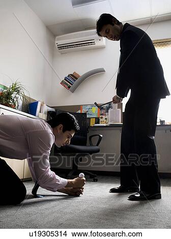 Picture - Executive holding a golf ball. Fotosearch