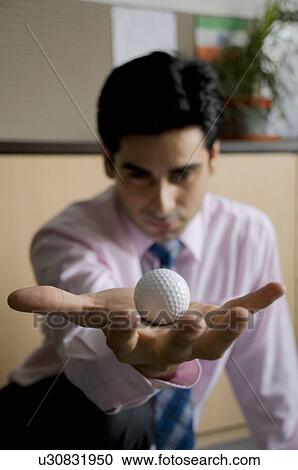 Stock Image - Executive holding a golf ball. Fotosearch