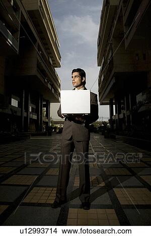 Picture - Executive holding a laptop. Fotosearch