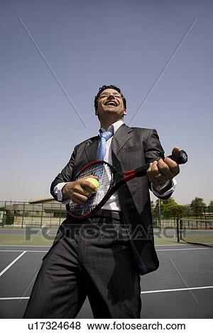 Executive holding a racket and a ball View Large Photo Image Stock Photo - Executive holding a racket and a ball. Fotosearch