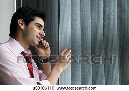 Stock Photograph - Executive talking on his cell phone. Fotosearch