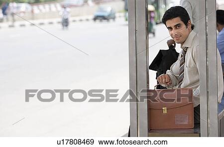 Stock Photo - Executive waiting at the bus stop. Fotosearch
