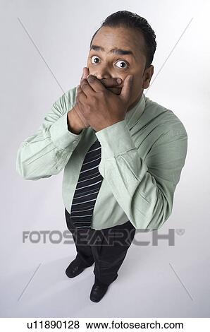 Executive with hands on his mouth View Large Photo Image Stock Photo - Executive with hands on his mouth. Fotosearch