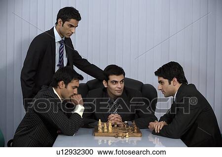 Stock Image - Executives playing chess. Fotosearch
