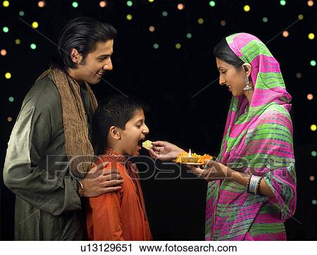 Stock Image - Family celebrating diwali. Fotosearch