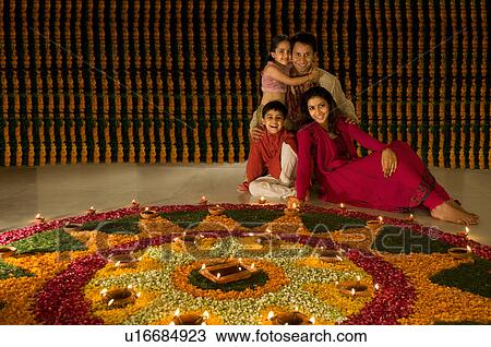 Stock Image - Family sitting near rangoli. Fotosearch