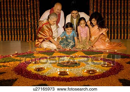 Stock Image - Family sitting near rangoli. Fotosearch
