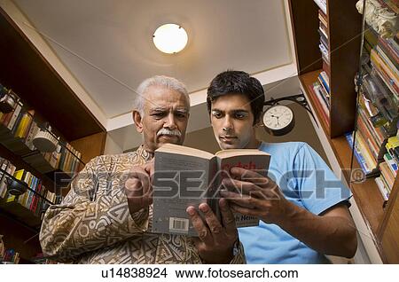 Picture - Father and son reading a book. Fotosearch