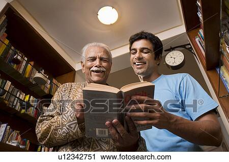 Father and son reading a book View Large Photo Image Stock Image - Father and son reading a book. Fotosearch